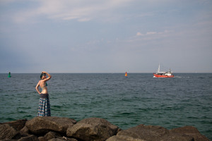 Ostseebad Warnemünde Frau auf der Westmole und Kutter auf der Ostsee