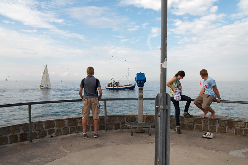 Warnemünde Touristen auf der Westmole im Hintergrund Kutter und Segelschiff auf der Ostsee