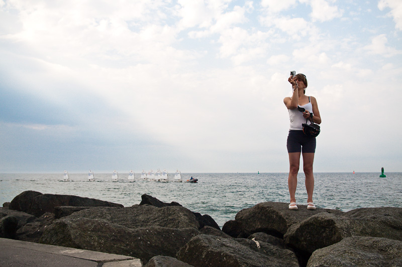 Warnemünder Woche Tourist fotografiert auf der Mole im Hintergrund Segelregatta auf der Ostsee