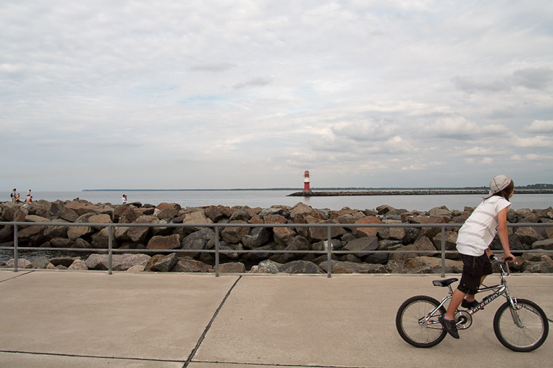 Warnemünde Blick von der Westmole auf die Ostmole im Vordergrund Kind mit Fahrrad