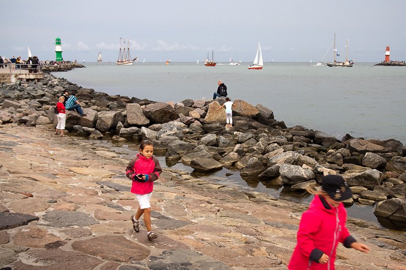 Hanse Sail Rostock Warnemünde Touristen und Kinder auf der Mole am Horizont Leuchttürme und Segelschiffe
