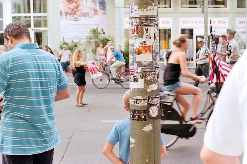 Berlin Touristen mit amerikanischer Flagge und Kind am Checkpoint Charlie
