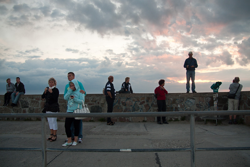 Hanse Sail Rostock Warnemünde Besucher stehen und sitzen auf der Mole im Sonnenuntergang